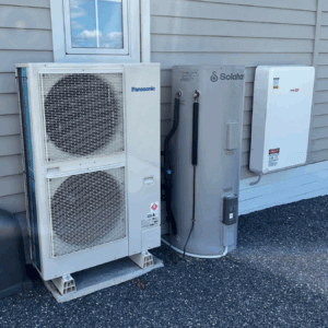 Panasonic outdoor air conditioning unit installed beside a Solahart hot water tank and SolarEdge inverter at a home in Launceston, Tasmania.